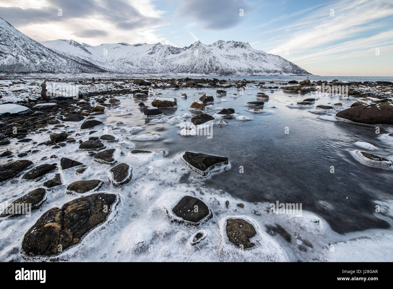 Norwegen, Troms, Torsken, Küste in der Nähe von Ballesvika, den schwankenden Wasserstand bildet eine Eis-Felsen auf den Steinen. Stockfoto