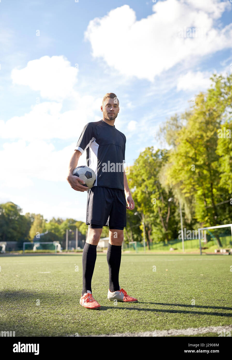 Fußballspieler mit Ball auf Fußballplatz Stockfoto