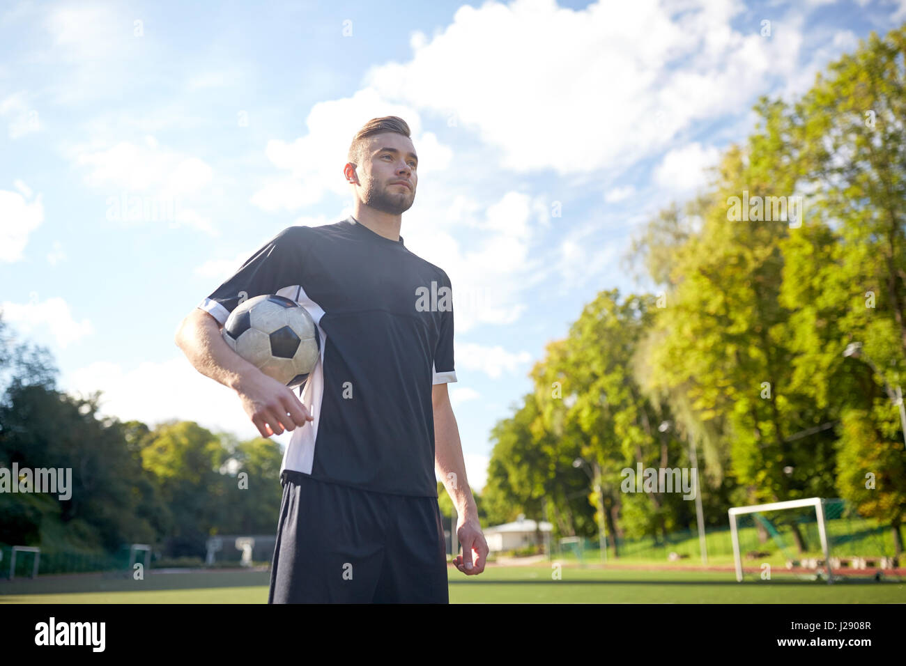 Fußballspieler mit Ball auf Fußballplatz Stockfoto