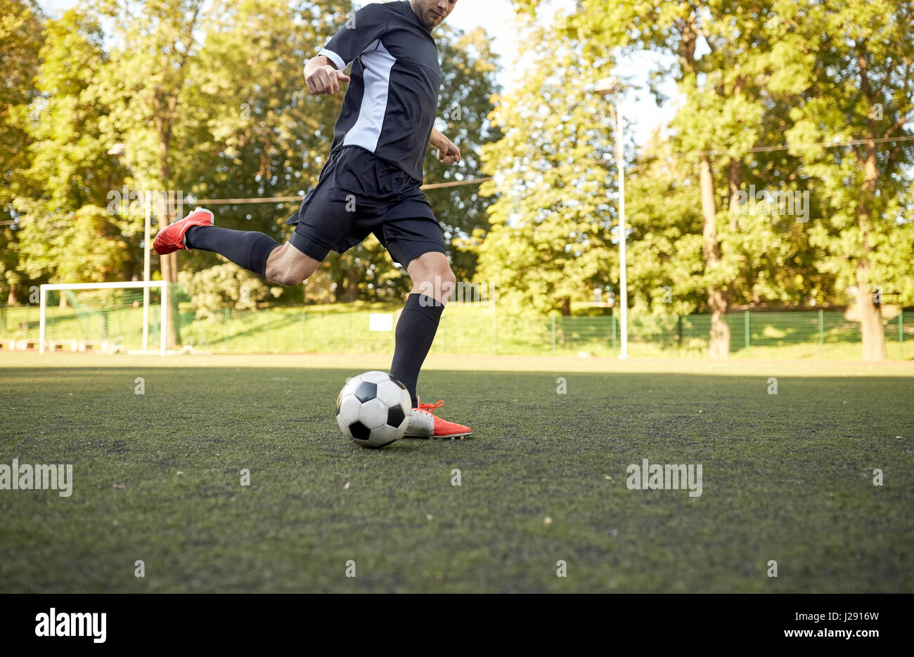 Fußballspieler mit Ball auf Fußballplatz spielen Stockfoto