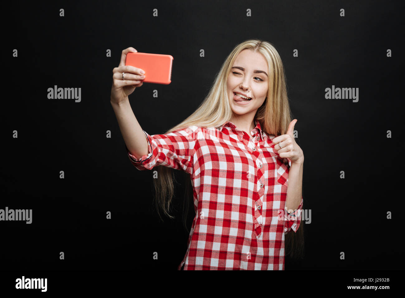 Lebendige Teenager nehmen Selfie auf schwarzem Hintergrund Stockfoto