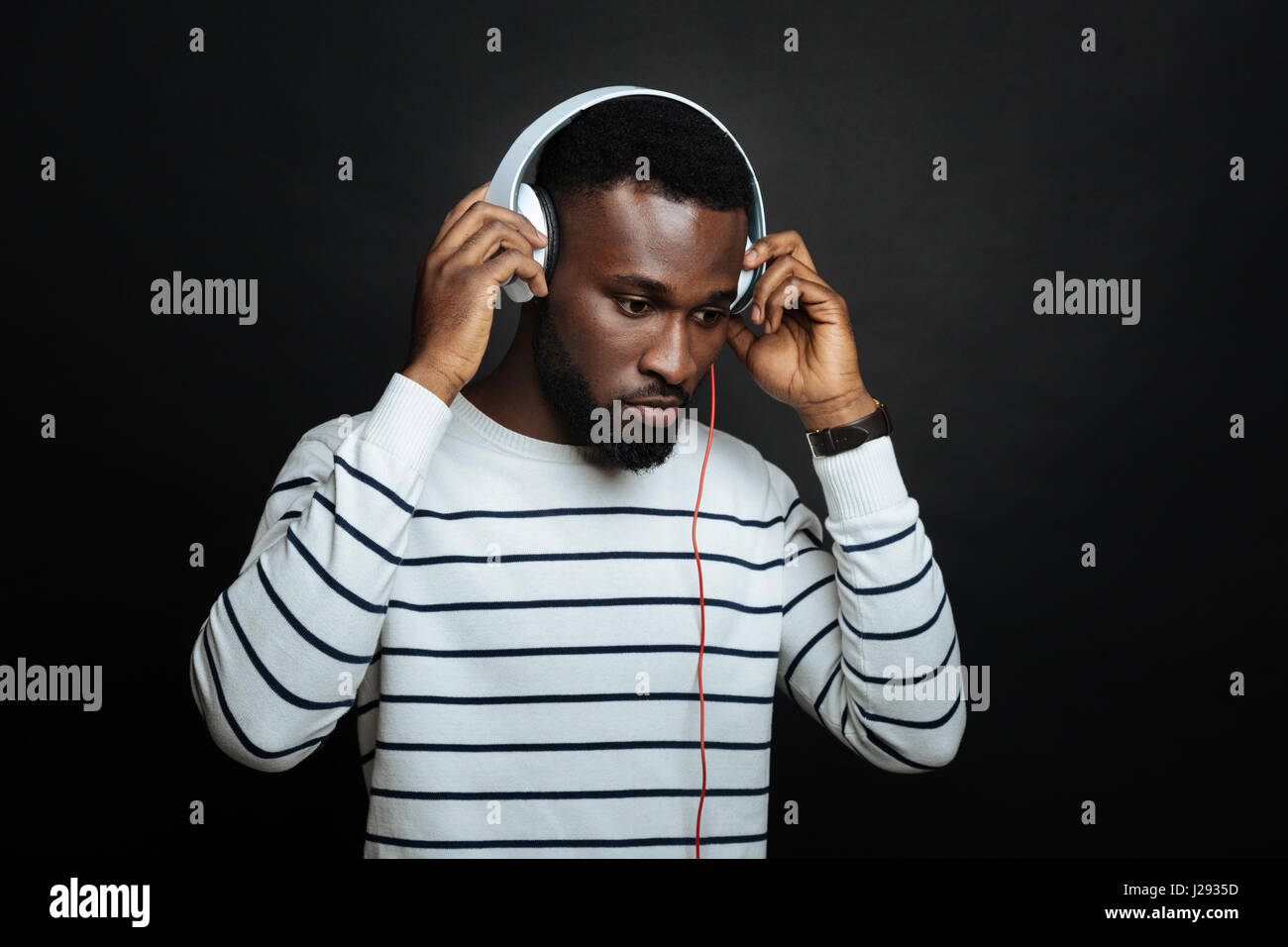 Interessierte afroamerikanische Mann mit Kopfhörern im studio Stockfoto