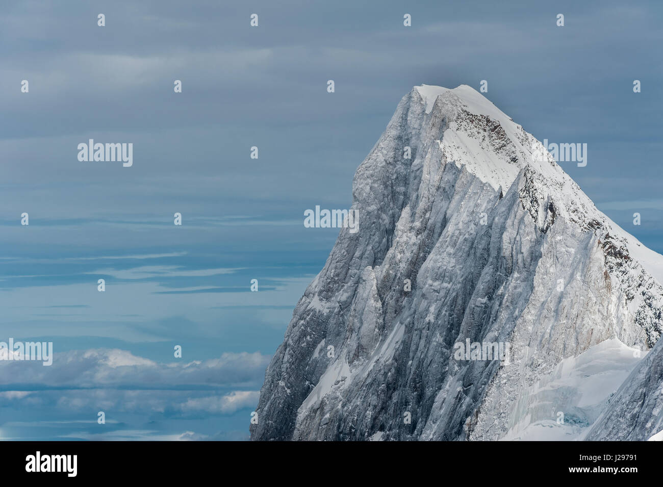 Die Grand Jorasses Nordwand durch den letzten Schnee und Eis vor einem wolkenverhangenen Himmelshorizont im Winter überdacht Stockfoto