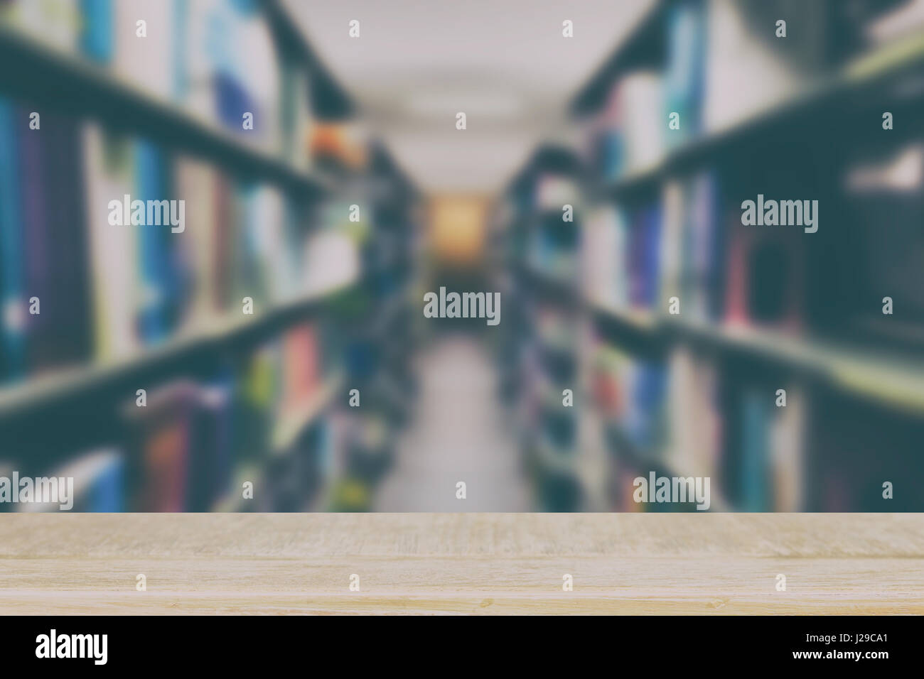 Innenraum der modernen Bibliothek mit grauen Buchregale, Unschärfe Hintergrund mit selektiven Fokus Holztisch für die Anzeige Ihres Produkts Stockfoto