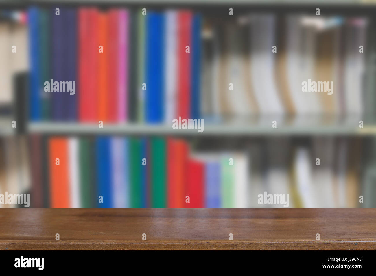 Innenraum der modernen Bibliothek mit grauen Buchregale, Unschärfe Hintergrund mit selektiven Fokus Holztisch für die Anzeige Ihres Produkts Stockfoto