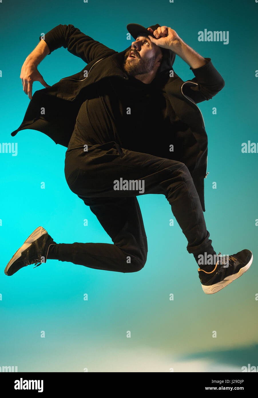 Die Silhouette von einem Hip-Hop-männliche Pause Tänzer tanzen auf farbigen Hintergrund Stockfoto