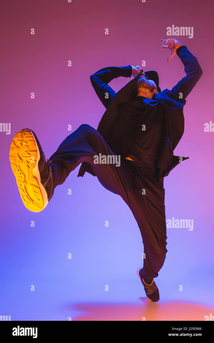 Die Silhouette von einem Hip-Hop-männliche Pause Tänzer tanzen auf farbigen Hintergrund Stockfoto