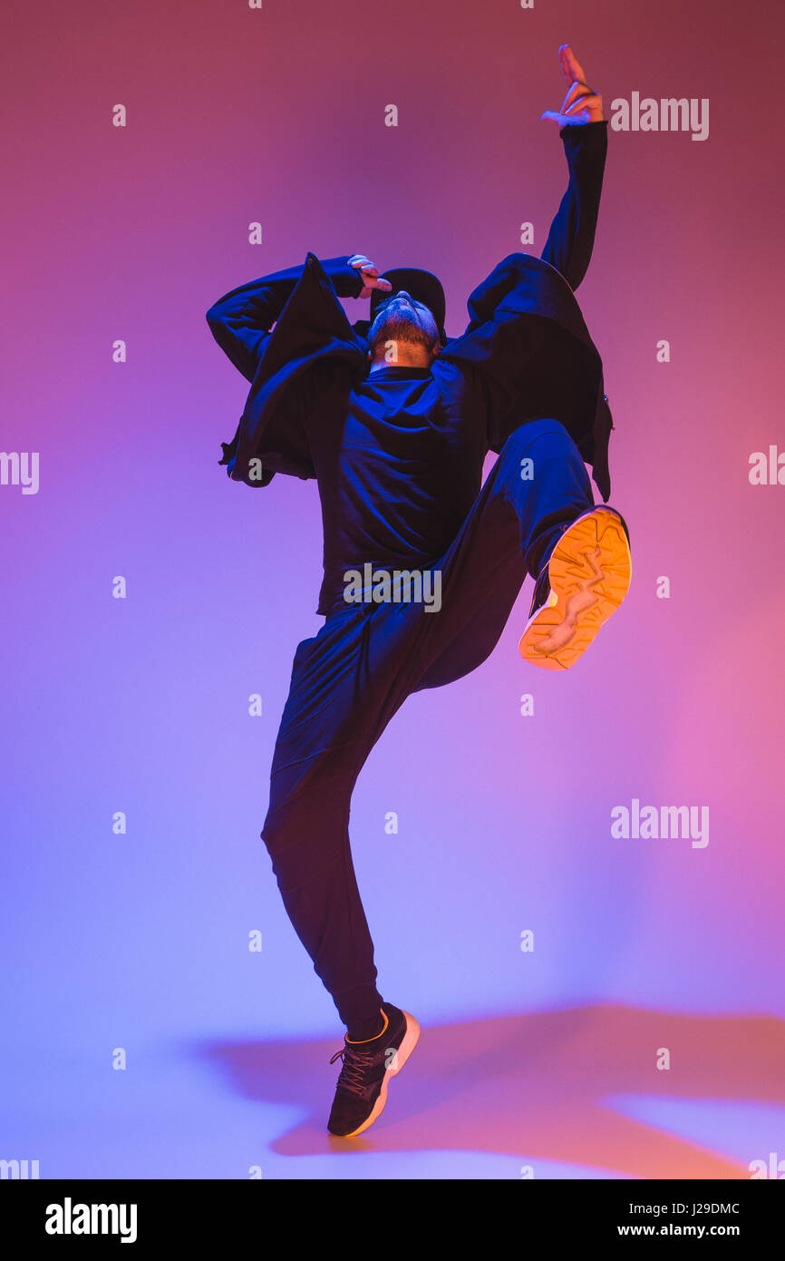 Die Silhouette von einem Hip-Hop-männliche Pause Tänzer tanzen auf farbigen Hintergrund Stockfoto
