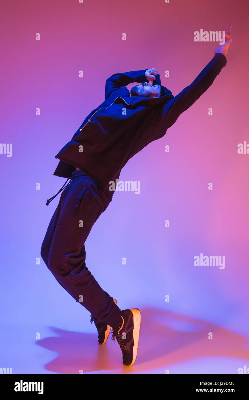 Die Silhouette von einem Hip-Hop-männliche Pause Tänzer tanzen auf farbigen Hintergrund Stockfoto