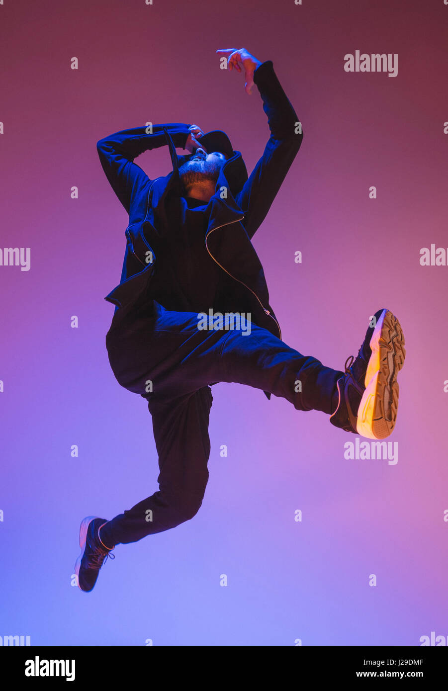 Die Silhouette von einem Hip-Hop-männliche Pause Tänzer tanzen auf farbigen Hintergrund Stockfoto
