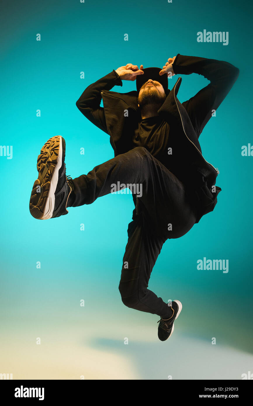 Die Silhouette von einem Hip-Hop-männliche Pause Tänzer tanzen auf farbigen Hintergrund Stockfoto