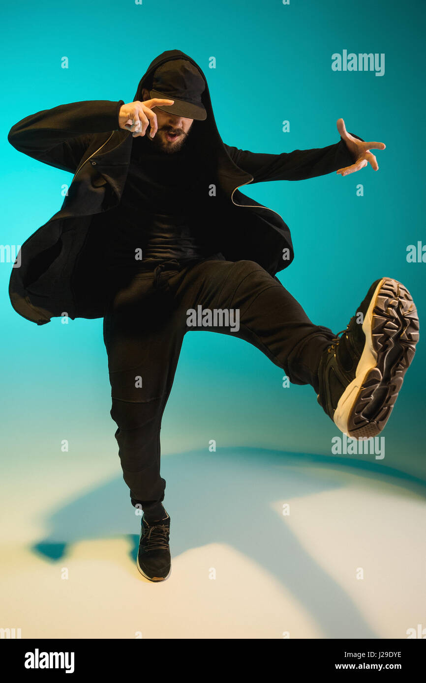 Die Silhouette von einem Hip-Hop-männliche Pause Tänzer tanzen auf farbigen Hintergrund Stockfoto
