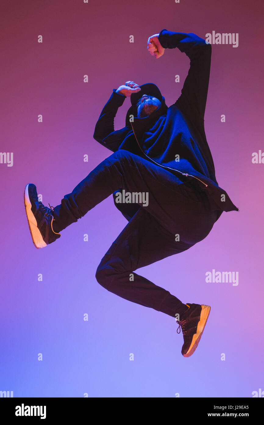 Die Silhouette von einem Hip-Hop-männliche Pause Tänzer tanzen auf farbigen Hintergrund Stockfoto