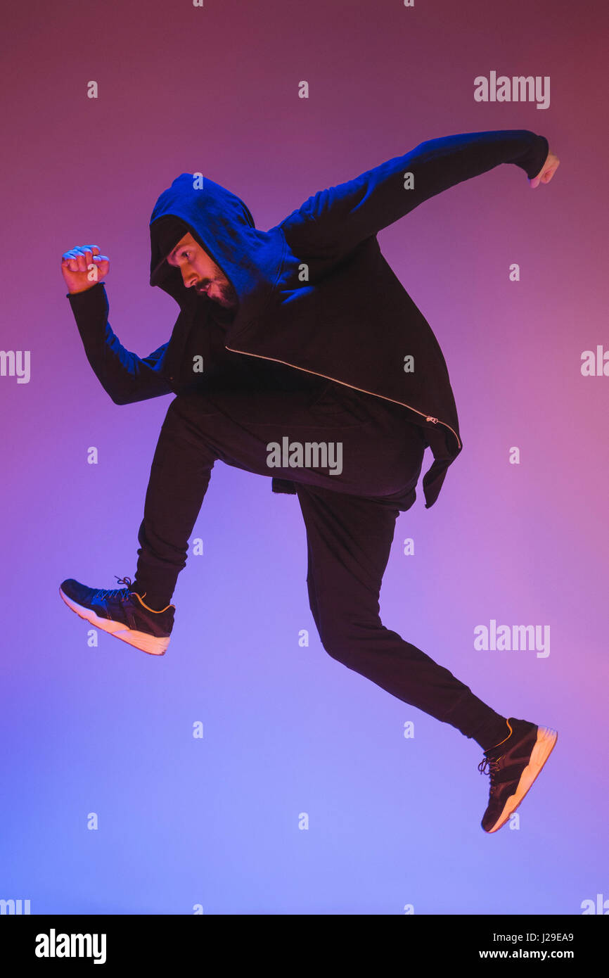 Die Silhouette von einem Hip-Hop-männliche Pause Tänzer tanzen auf farbigen Hintergrund Stockfoto