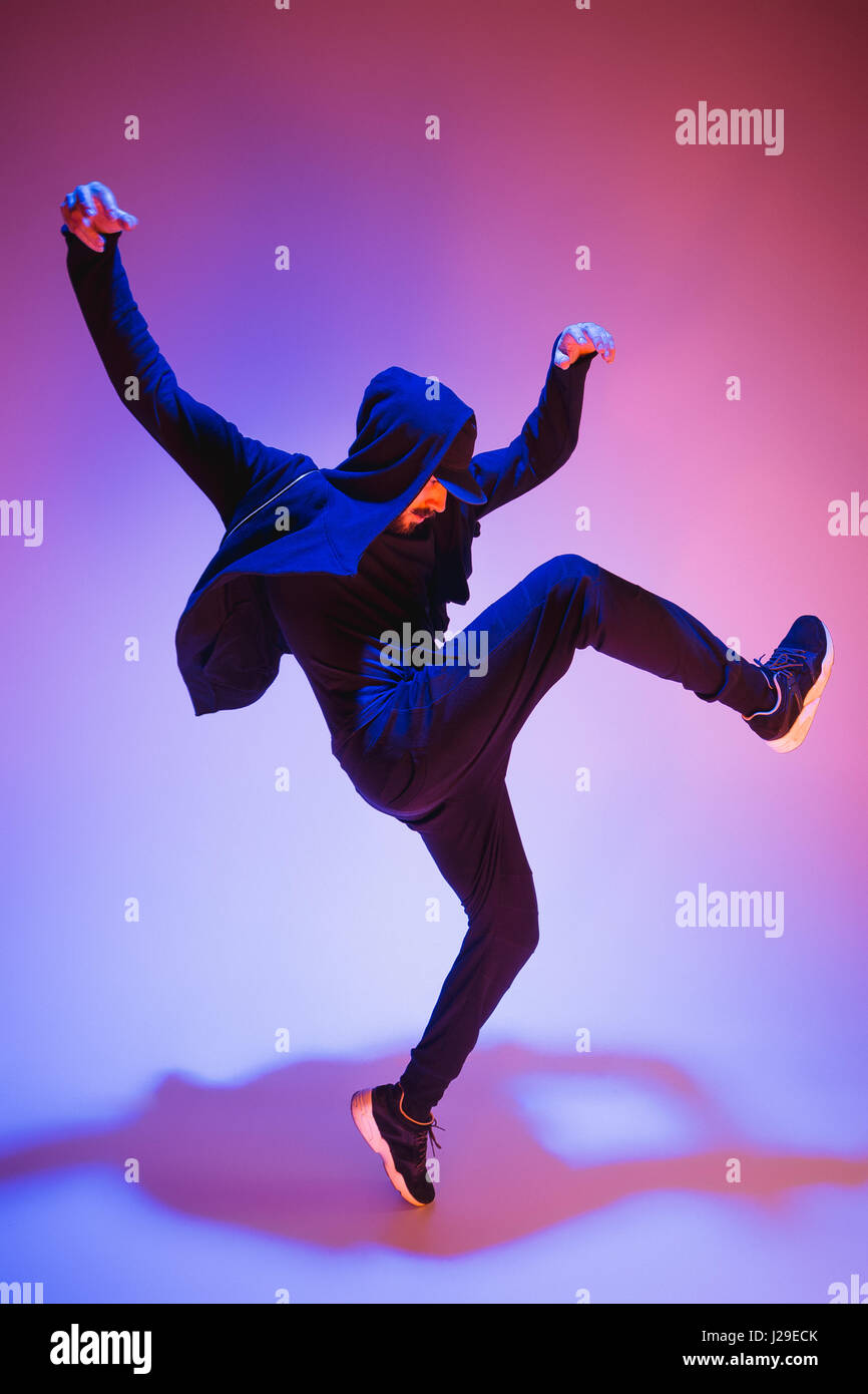 Die Silhouette von einem Hip-Hop-männliche Pause Tänzer tanzen auf farbigen Hintergrund Stockfoto