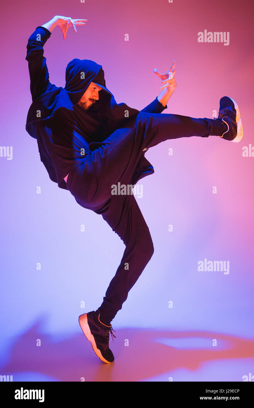 Die Silhouette von einem Hip-Hop-männliche Pause Tänzer tanzen auf farbigen Hintergrund Stockfoto