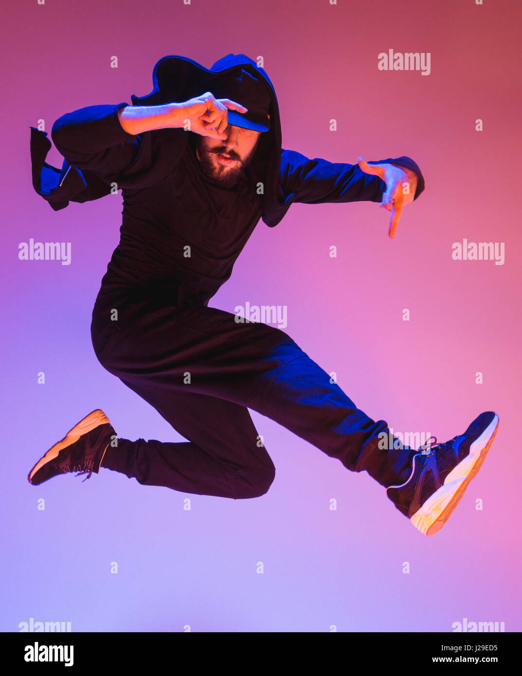 Die Silhouette von einem Hip-Hop-männliche Pause Tänzer tanzen auf farbigen Hintergrund Stockfoto