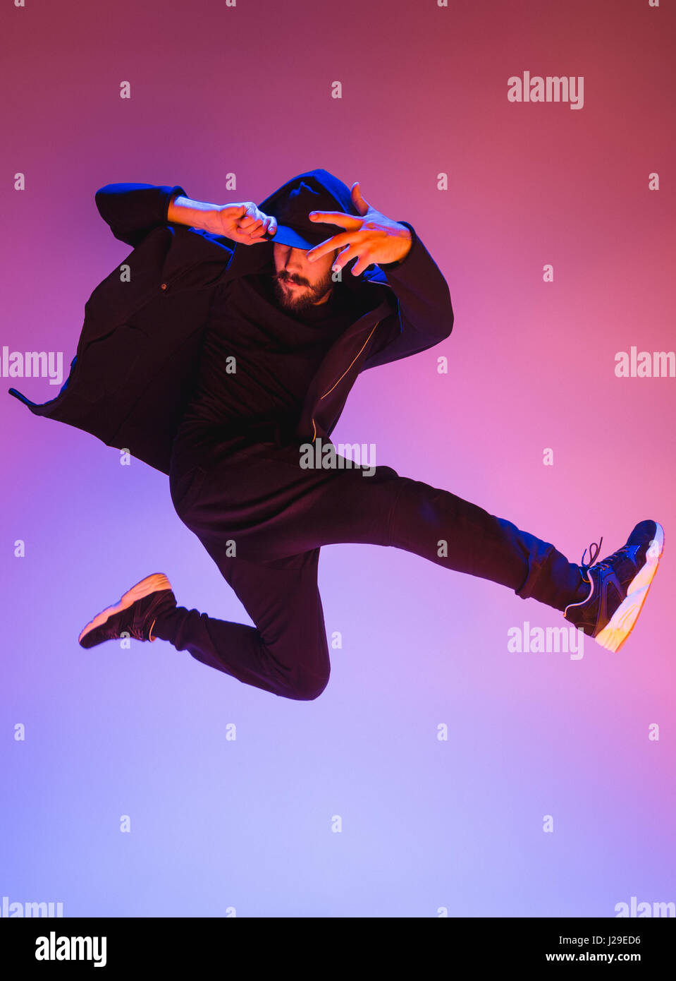 Die Silhouette von einem Hip-Hop-männliche Pause Tänzer tanzen auf farbigen Hintergrund Stockfoto