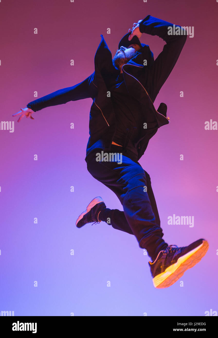 Die Silhouette von einem Hip-Hop-männliche Pause Tänzer tanzen auf farbigen Hintergrund Stockfoto
