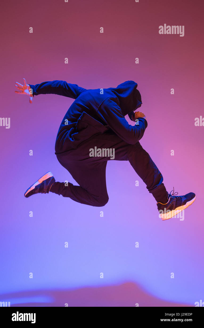 Die Silhouette von einem Hip-Hop-männliche Pause Tänzer tanzen auf farbigen Hintergrund Stockfoto