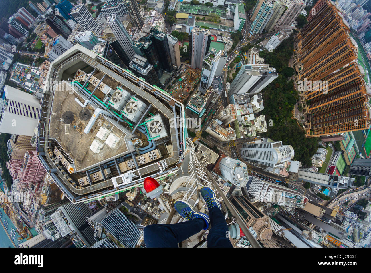 Rooftopper Denis Krasnov schaut hinunter auf die Stadt. Atemberaubende Bilder aus einem Team von Nervenkitzel, die Eroberung Dächer über 800 Fuß hohen es unmöglich machen, nicht nach unten. Diese Schwindel induzierenden Bilder wurden gemacht, als die Gruppe der Draufgänger Hongkong auf eine Entdeckungsreise besuchte. Die Aufnahmen zeigen die Gruppe hängen von der Seite des Gebäude, mit Blick auf den hektischen Verkehr unten und an der Spitze der Metallsäule ohne Fangvorrichtung ausgleichend. Die atemberaubenden Bilder wurden von russischen Fotografen Denis Krasnov (20). Wenn er zum ersten Mal der Idee, Reisen nach Hong Kong, Denis Stockfoto