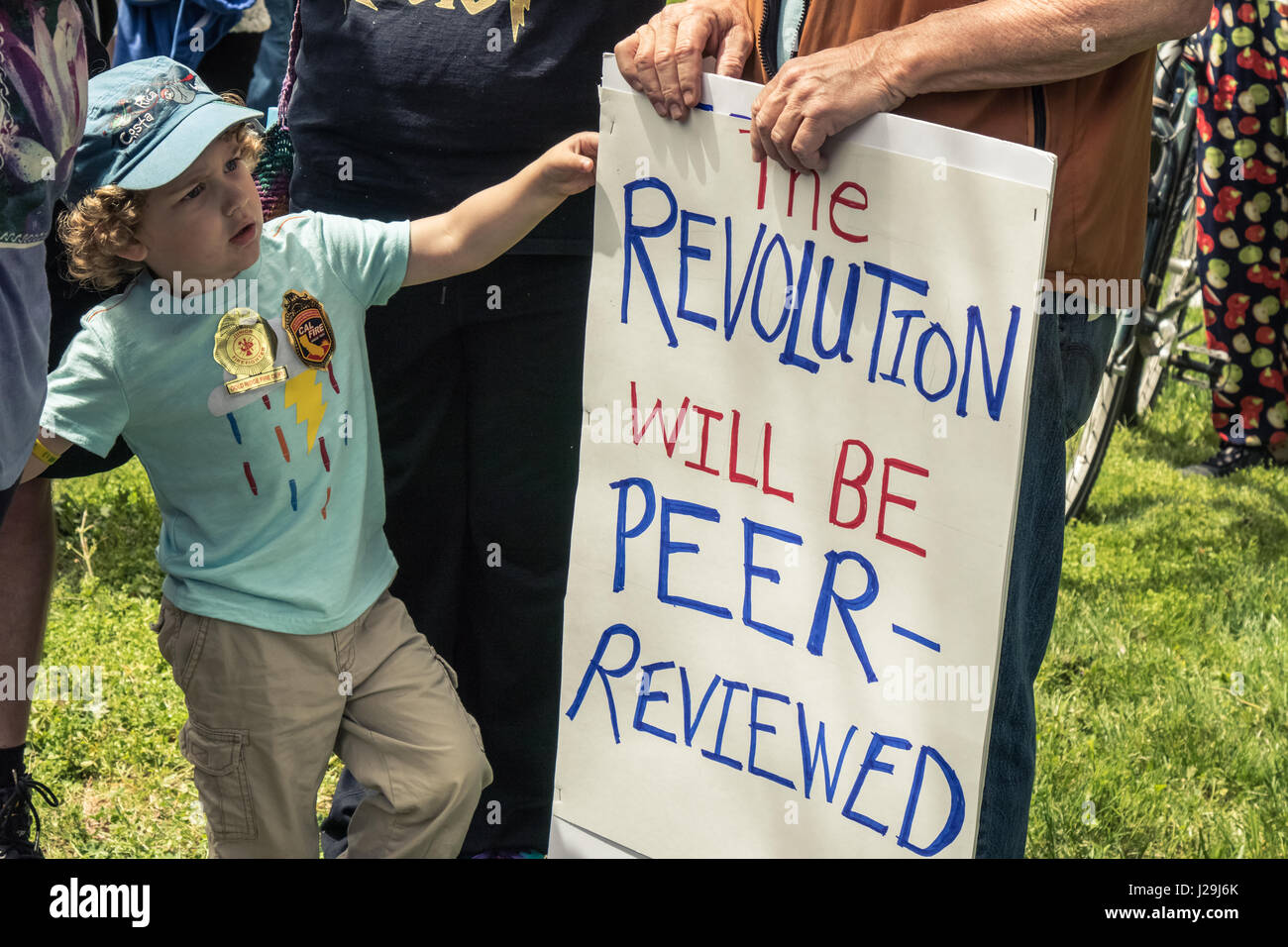 23.04.2017 - SANTA ROSA, KALIFORNIEN. USA - steht ein kleiner Junge neben ein Zeichen über Revolution während des Marsches für die Wissenschaft am Earth Day. Stockfoto