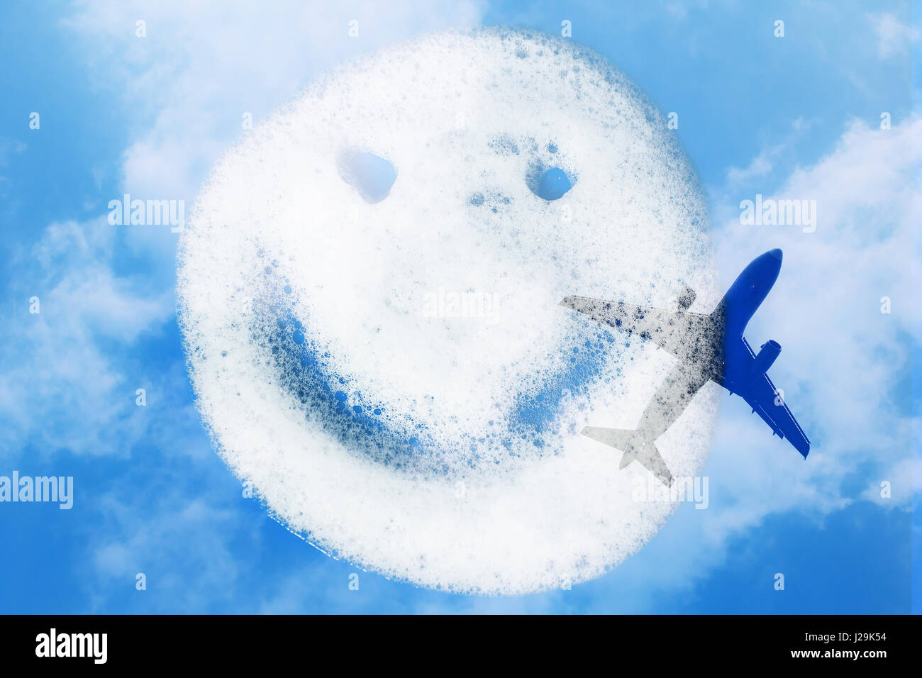 Smiley der Seifenlauge auf blauem Hintergrund mit Flugzeug und Himmel. Doppelbelichtung Stockfoto