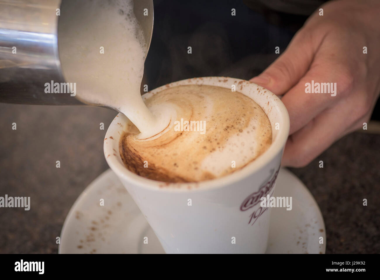 Nahaufnahme; Cappuccino; Kaffee; Zubereitung; Zubereiten; Milch; schaumige Milch; gegossen; Gießen; Barrista; Kaffeepause Stockfoto