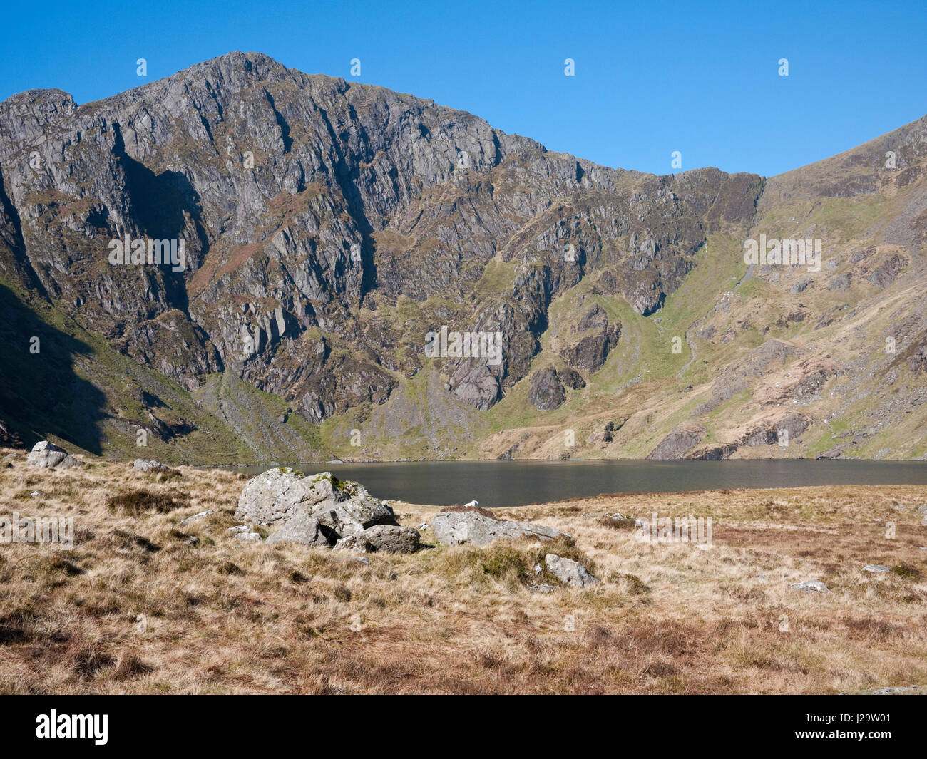 Die Klippen von Craig Cau Turm über den See Llyn Cau im Cwm Cau, unterhalb der Gipfel des Cadair Idris, im Snowdonia National Park, North Wales Stockfoto