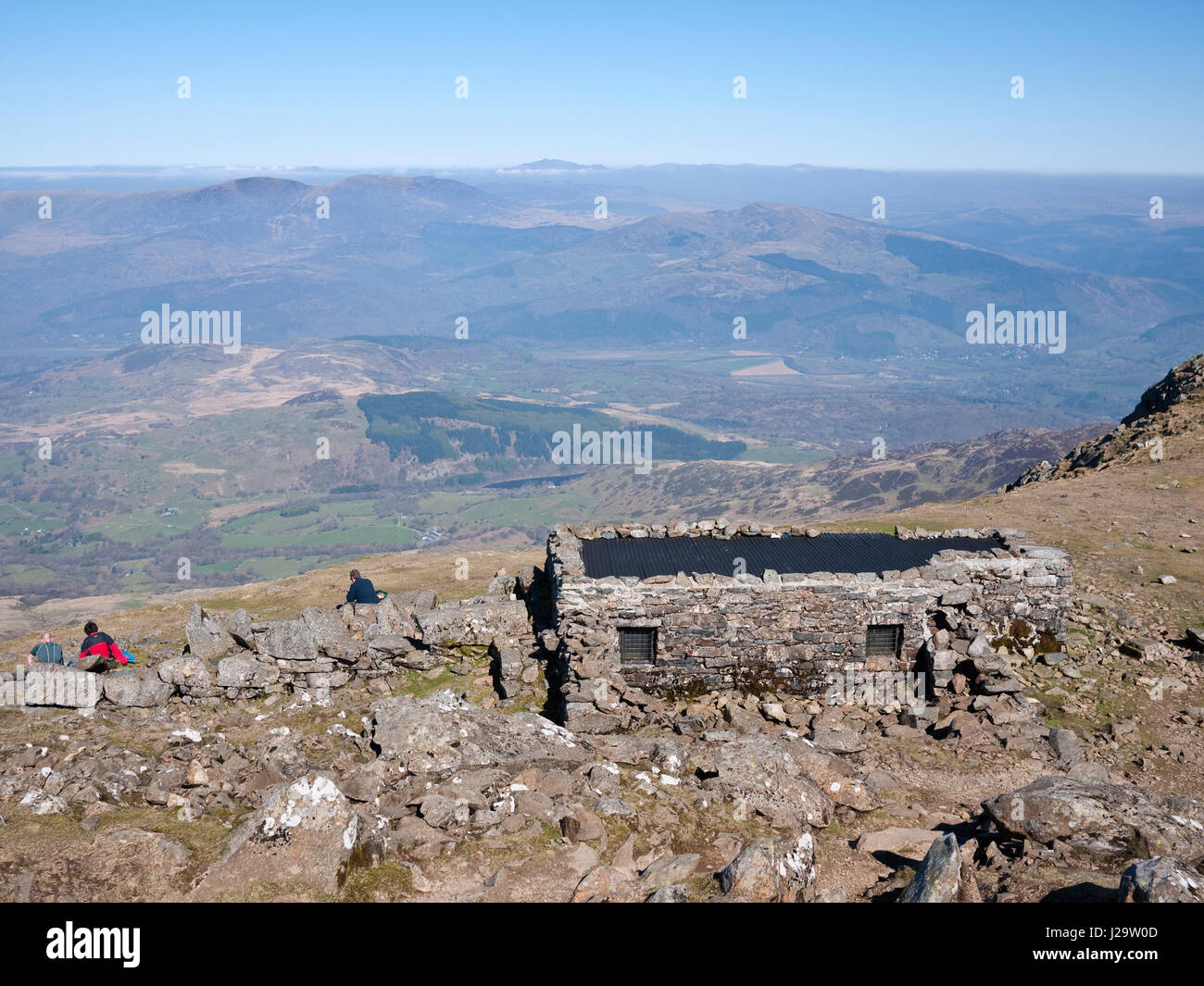 Wanderer außerhalb des Gipfels Zuflucht auf Cadair Idris. Die Aussicht ist im Norden, über den Rhinog Mountains zu einem weit entfernten Snowdon Stockfoto