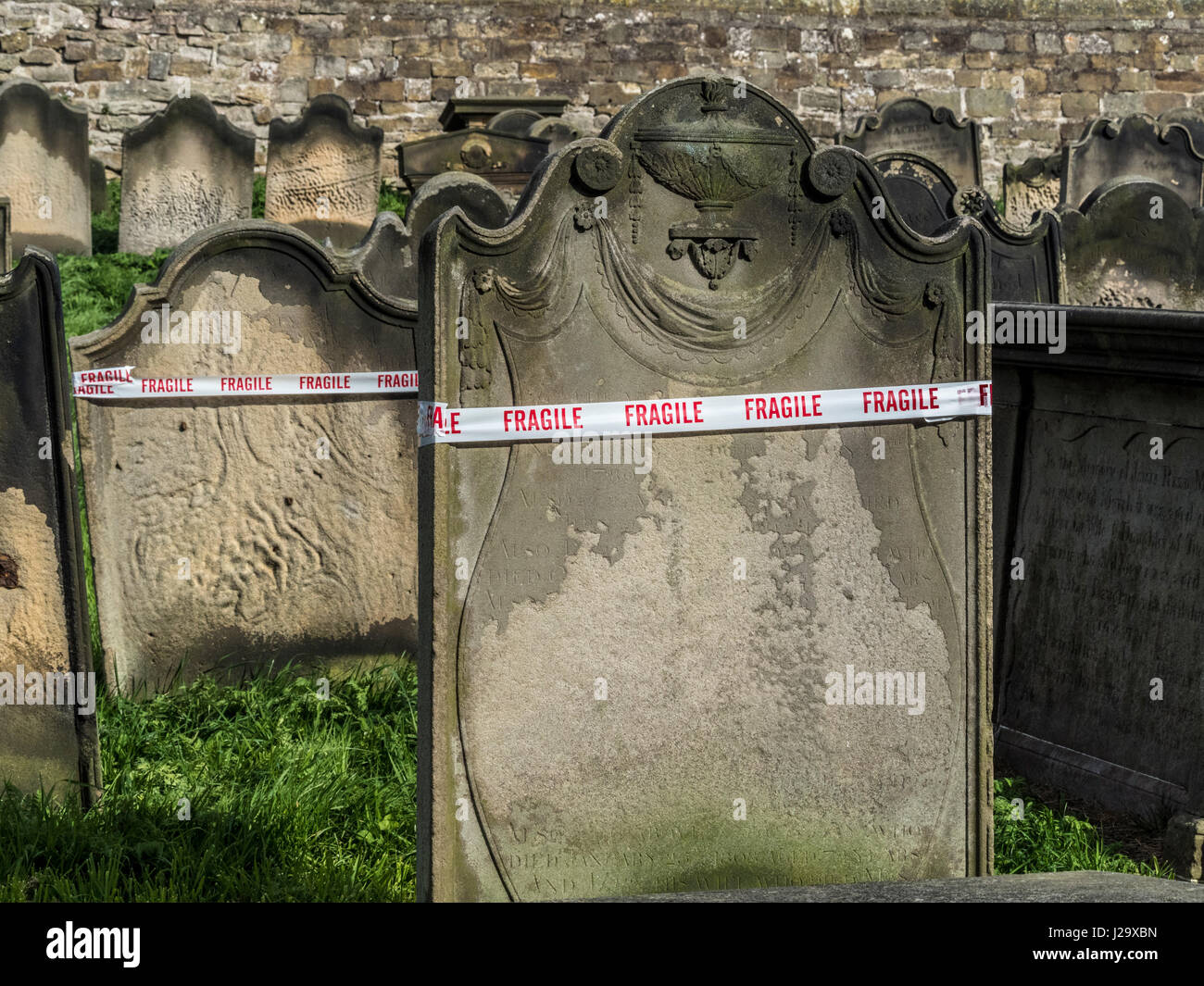 Fragile Band um Grabsteine in Str. Marys Kirche Friedhof, Whitby, Großbritannien. Stockfoto