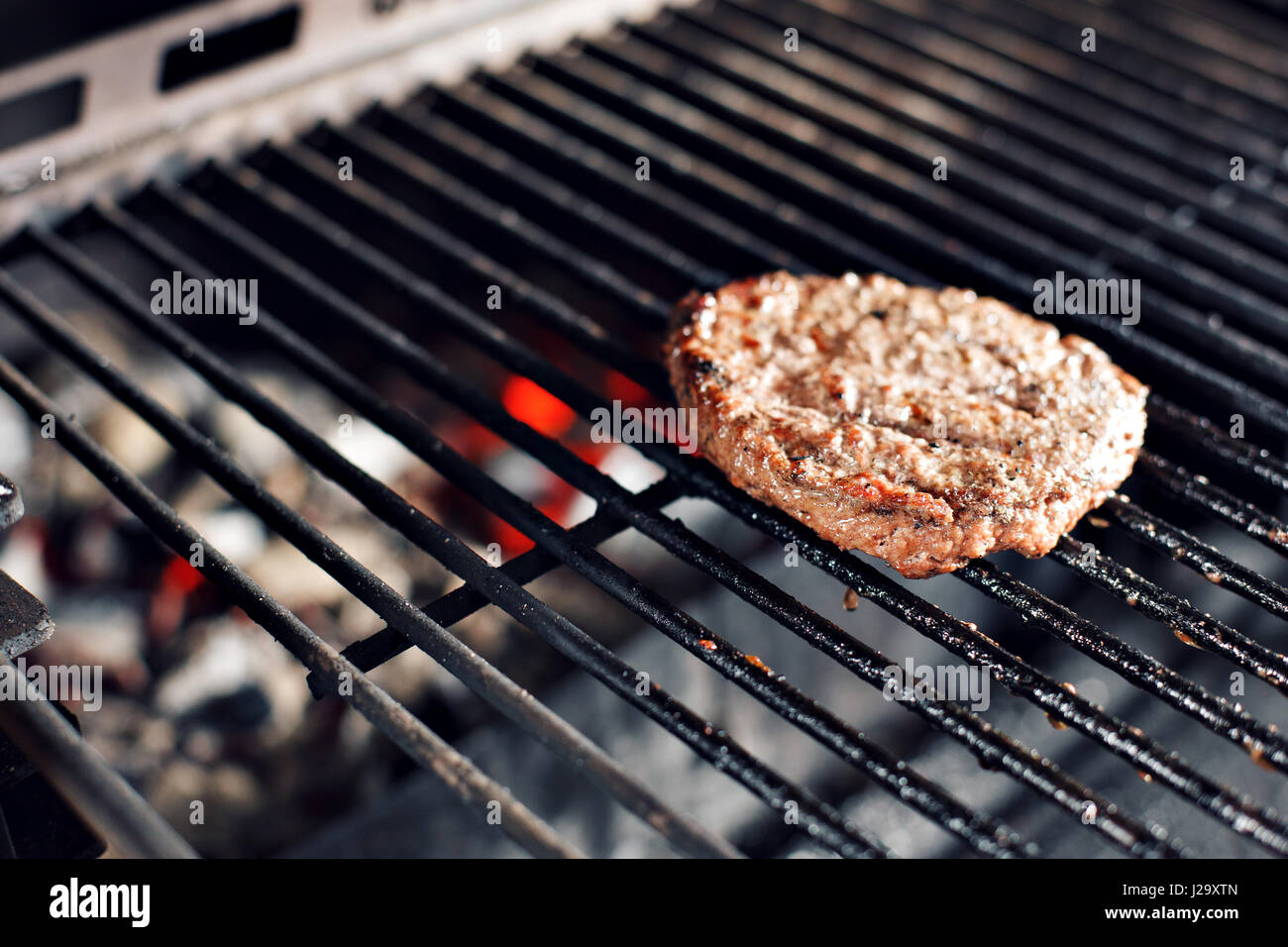 Beef Burger und Spachtel auf den Heißen lodernden BBQ Holzkohlegrill, Close-up Stockfoto