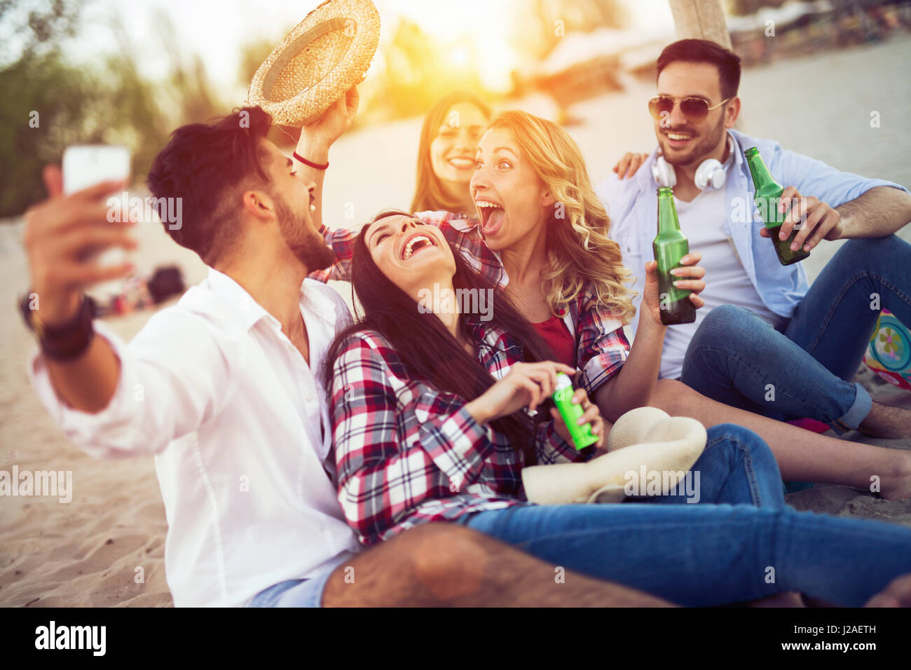 Glückliche Menschen trinken und Spaß am Strand im Sommer Stockfoto