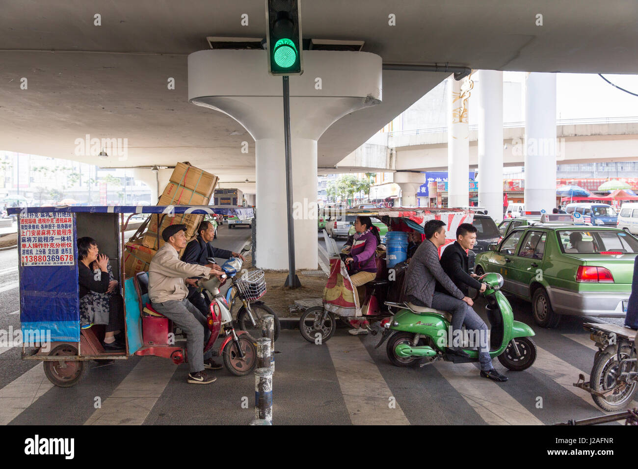China, Provinz Sichuan, Chengdu, chaotisch durcheinander, Motorräder, Fahrräder und Fußgänger Straße im Stau unter erhöhten Schnellstraße überqueren Stockfoto