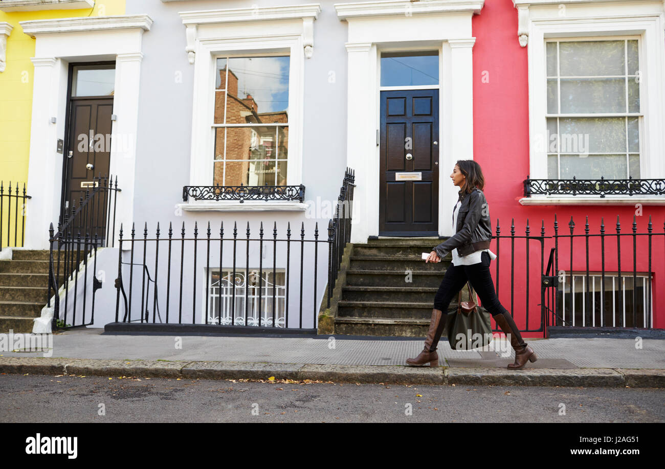 Gemischte Rassen junge Frau zu Fuß auf London Street mit Telefon Stockfoto