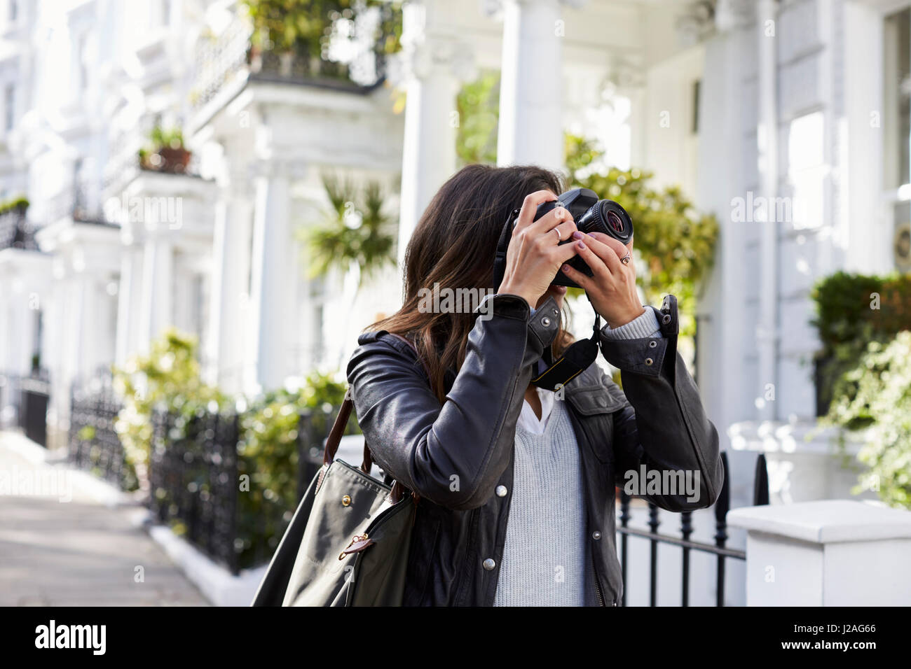 Junge Frau, die Aufnahme in eine Residenzstadt Straße Stockfoto