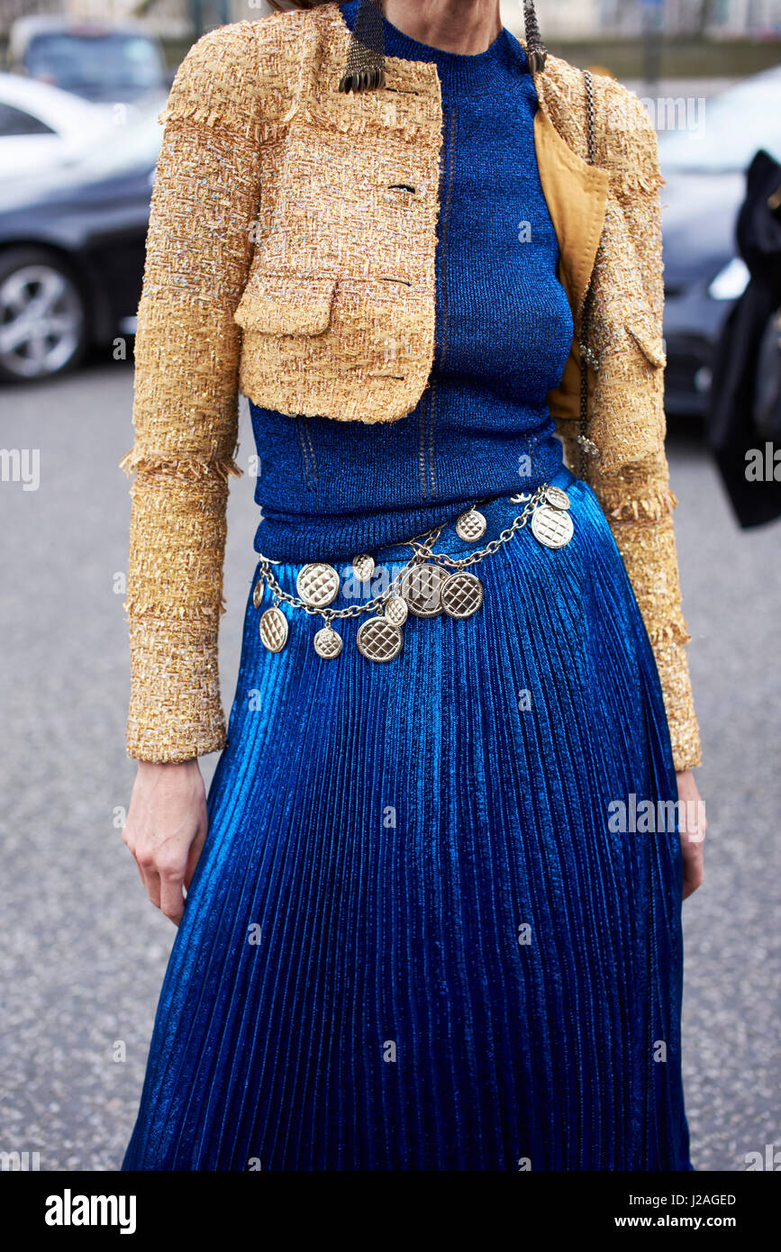 LONDON - Februar 2017: Mittelteil Frau trägt eine kurze Wolljacke anzeigen, langen blauen Faltenrock und Chanel Medaillon Kettengürtel auf der Straße während der London Fashion Week, vertikal, vorne Stockfoto