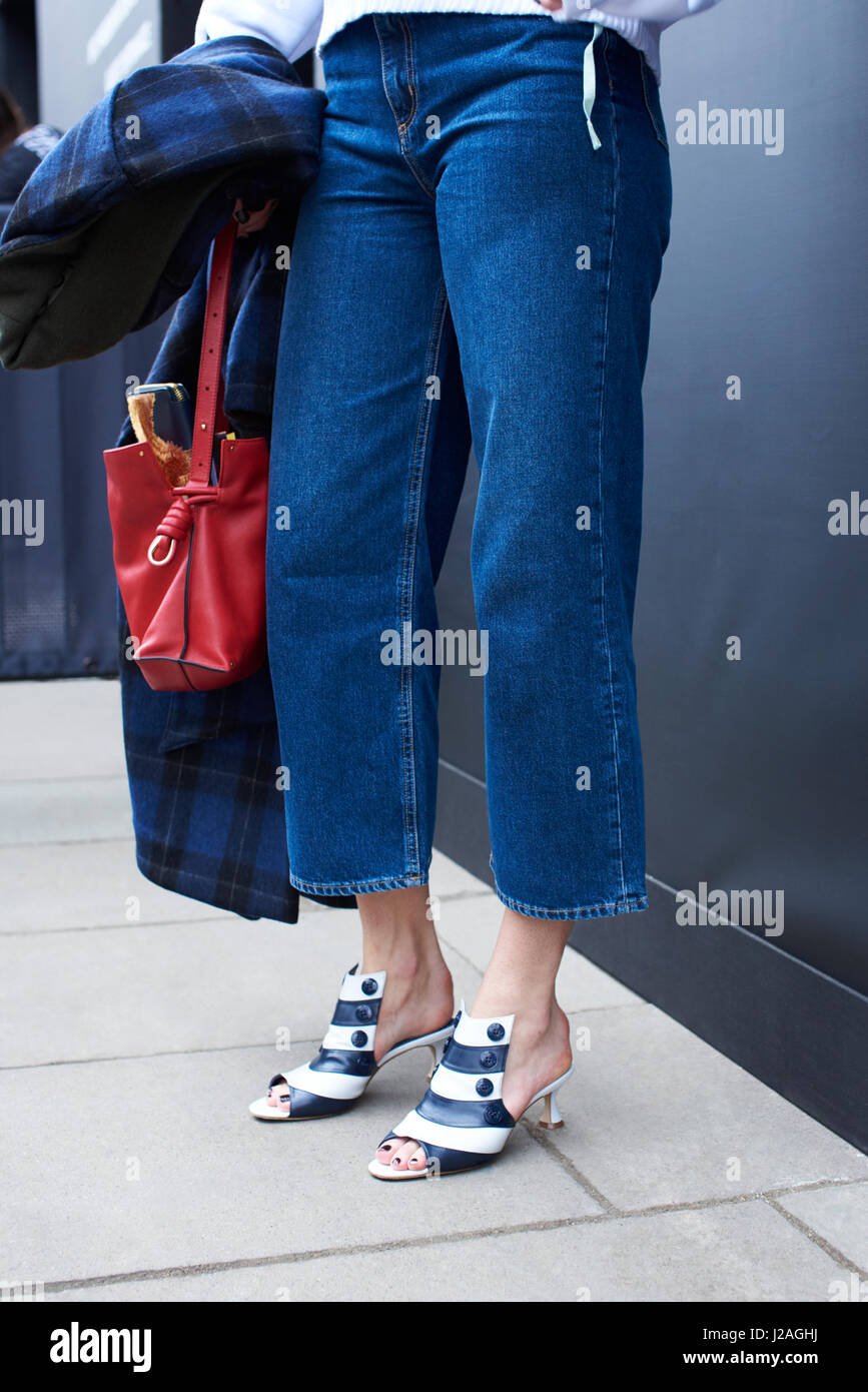 LONDON - Februar 2017: Niedrige Teil der Trägerin Dreiviertel Länge Jeans und Kätzchen Ferse gestreift Leder zehenoffenen Pantoletten stehen auf der Straße während der London Fashion Week, vertikale Stockfoto