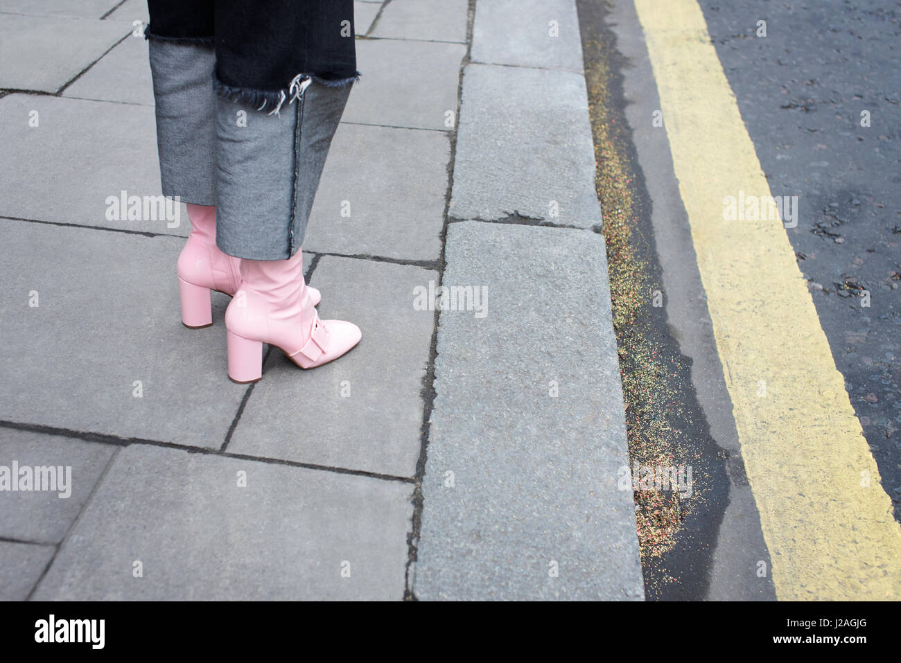 LONDON - Februar 2017: Niedrige Teil der modebewusste Frau trägt Jeans mit übergroßen 38er und Rosa Leder Stiefel stehen auf der Straße während der London Fashion Week, horizontale Stockfoto