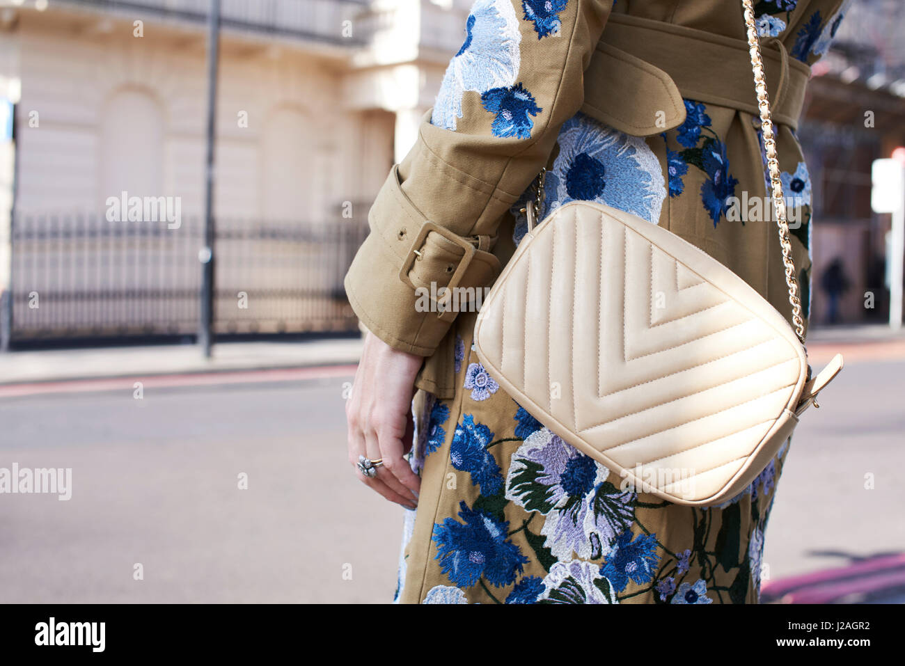 LONDON - Februar 2017: Mittelteil trägt weiße Frau Chanel cross Body Handtasche und Mantel mit Blumenschmuck in der Straße während der London Fashion Week Stockfoto