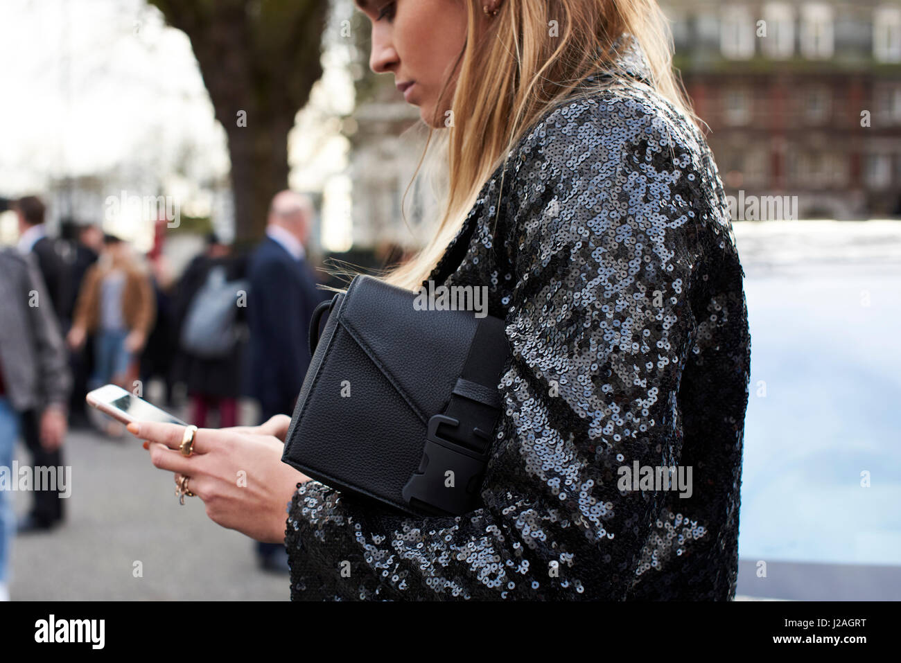 LONDON - Februar 2017: Hüfte aufwärts Blick auf Frau mit Smartphone in der Straße außerhalb Christopher Kane Fashion Show, London Fashion Week, Tag vier. Stockfoto