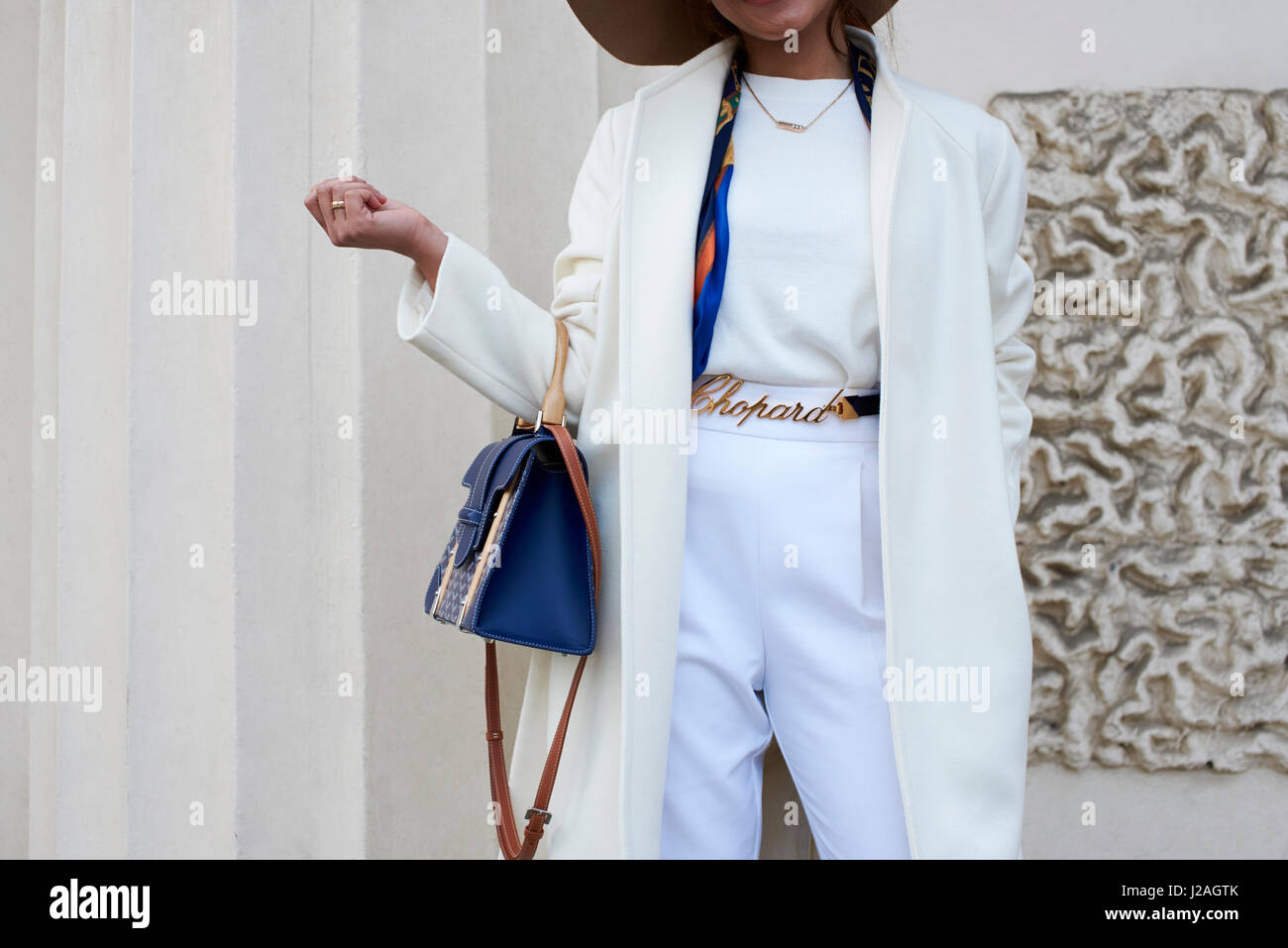 LONDON - Februar 2017: Mittelteil der Frau tragen, weiße Hose, Mantel und Chopard Metallband hält eine blaue Handtasche auf der Straße gegen ein Gebäude, London Fashion Week, Tag vier. Stockfoto