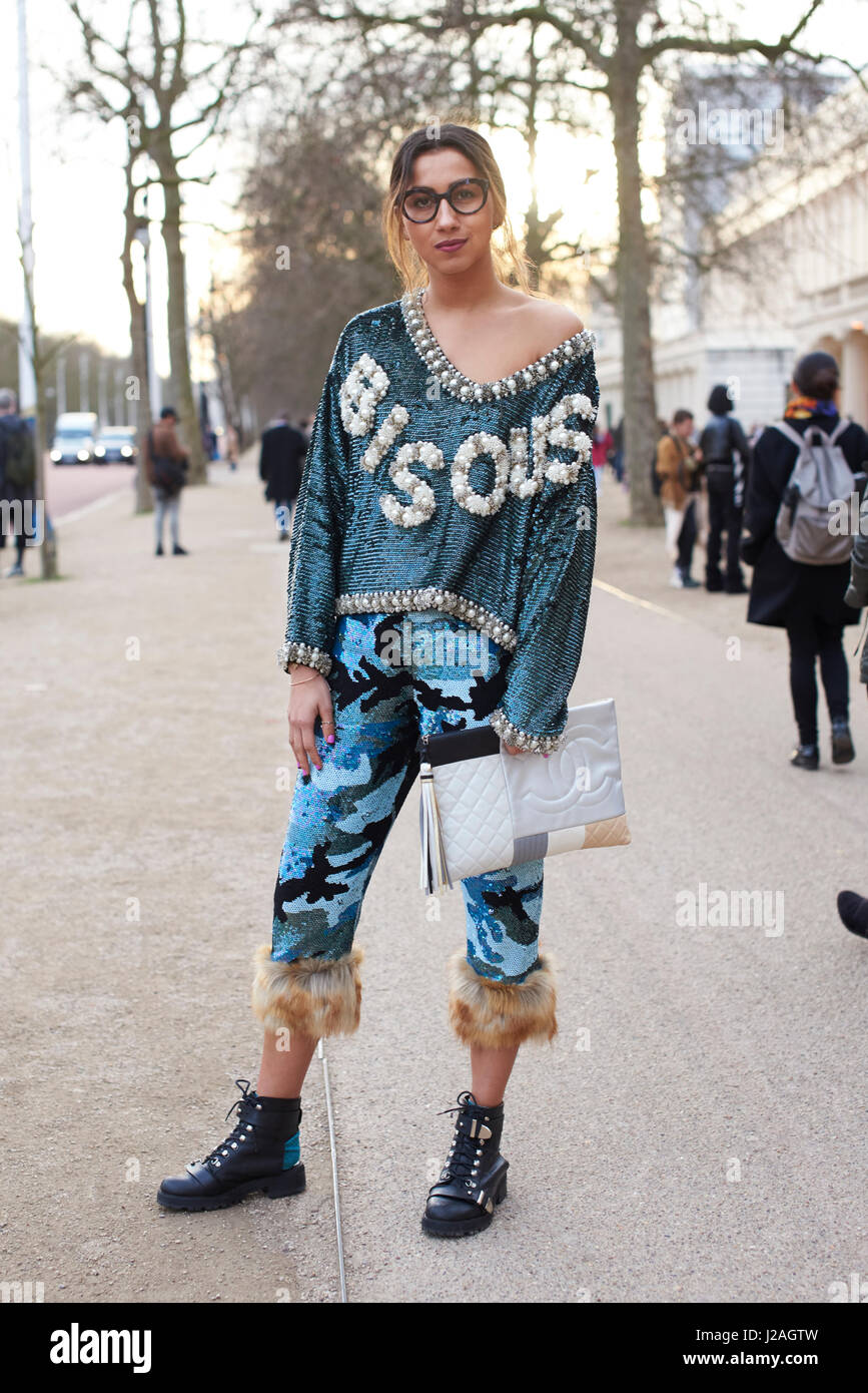 LONDON - Februar 2017: Volle Länge Blick auf weibliche Mode-Blogger tragen Ashish Hose und Oberteil, mit einer übergroßen Chanel Kupplung Handtasche Stand in der Straße, London Fashion Week, Tag vier. Stockfoto