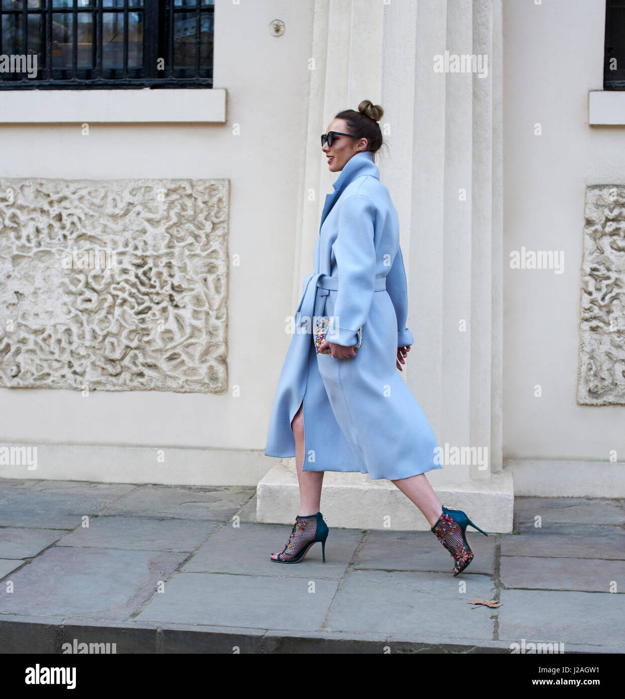LONDON - Februar 2017: Anblick Frau in blassen blauen Mantel und high Heels, die zu Fuß in die Stadt Street, London Fashion Week, Tag 4, in voller Länge. Stockfoto