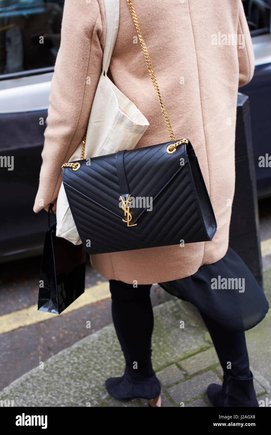 LONDON - Februar 2017: Niedrige Abschnitt Rückansicht der Frau trägt eine schwarze Yves Saint Laurent cross in Street, London Fashion Week, Tag fünf Körper Handtasche stehen. Stockfoto