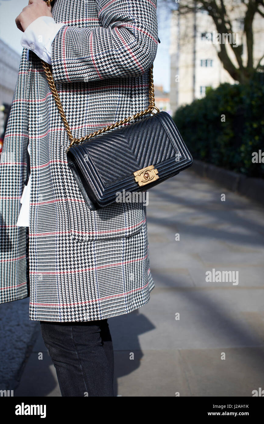 LONDON - Februar 2017: Mittelteil der Trägerin Glencheck überqueren, Mantel und schwarzen Chanel Körper Handtasche stehen in der Straße während der London Fashion Week Stockfoto