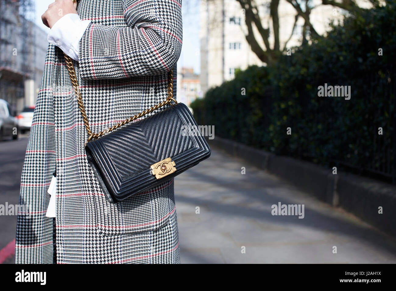 LONDON - Februar 2017: Mittelteil der Trägerin Zara überqueren Sie Körper Handtasche mit Metall-Details und blauen Mantel auf Schultern in der Straße während der London Fashion Week Stockfoto
