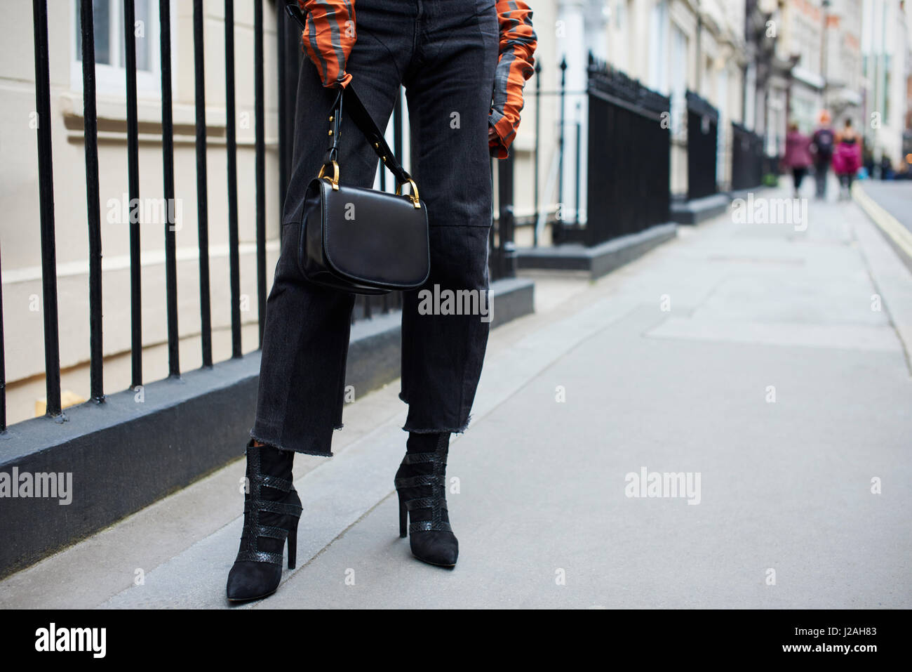 Frau in gestreiften Top tragen Designer-Handtasche, niedrige Abschnitt Stockfoto
