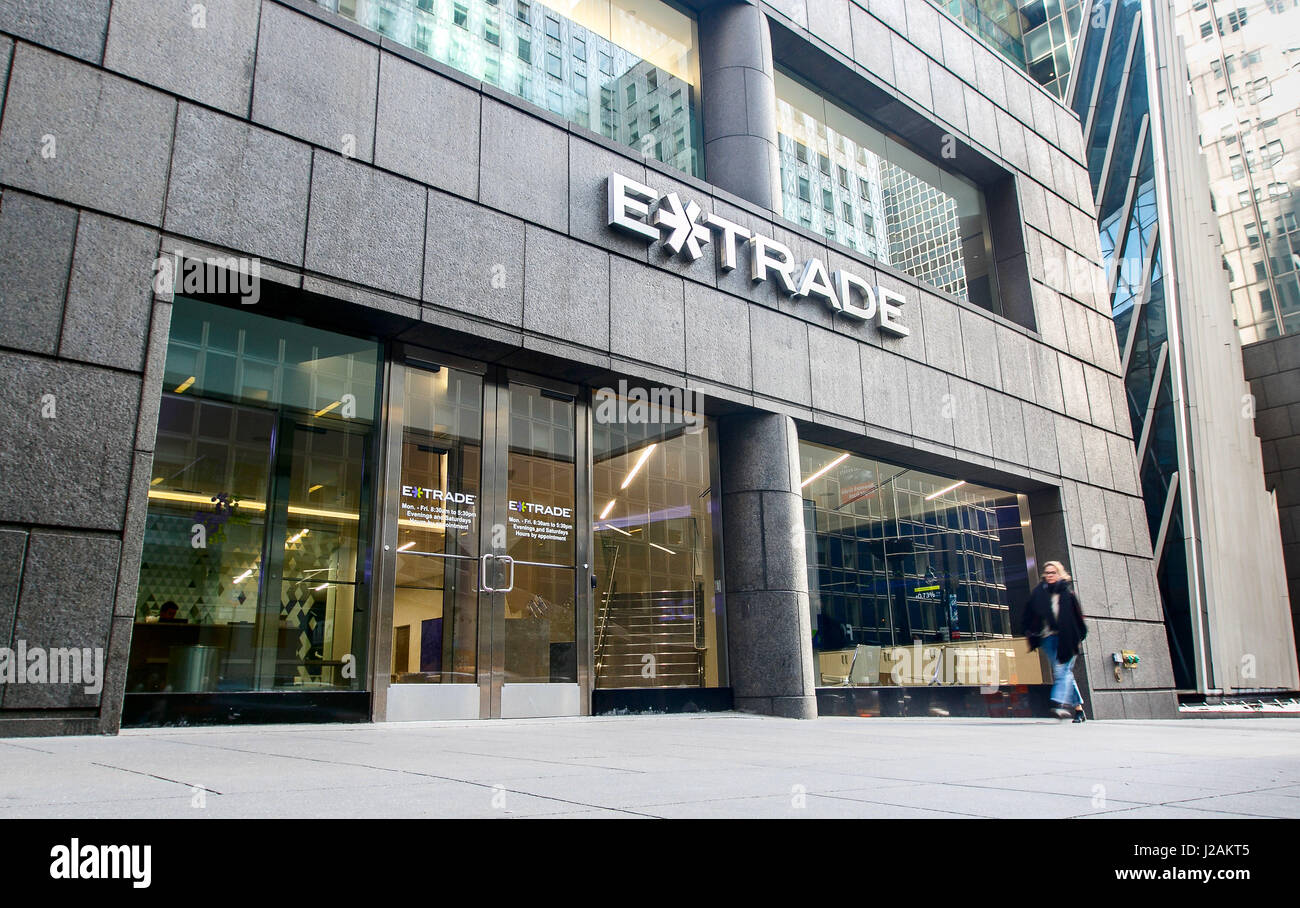 A woman is walking by an ETrade office on 42nd street. Stockfoto