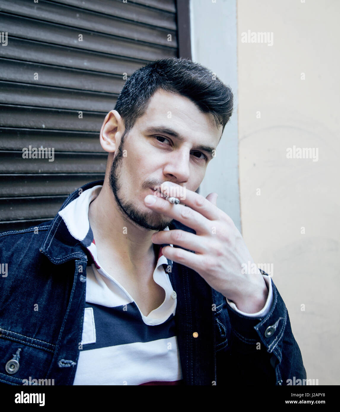 mittleren Alter Mann Rauchen Zigarette auf Bacyjard, stilvolle harter Kerl, Lifestyle-Konzept Menschen hautnah Stockfoto